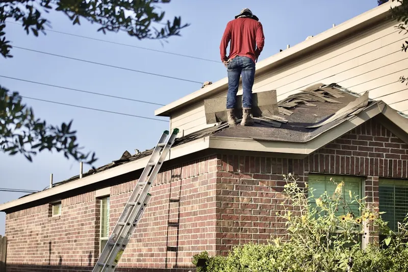 Professional roofer working on a residential roof in Haggin Park